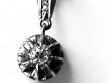photo en noir et blanc d'un pendentif en forme de diamant sur fond blanc