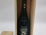 la bouteille de vin se trouve dans une caisse en bois, à côté d'un morceau de bois