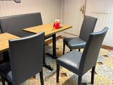 une table et des chaises dans un restaurant, avec une enseigne accrochée au mur