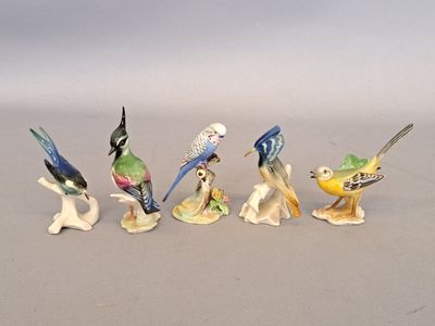 cinq figurines d'oiseaux alignées sur une table