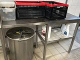 une grande poubelle en métal posée sur le plan de travail de la cuisine