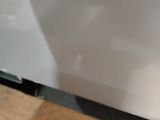 a white refrigerator sitting on a wooden floor next to a window