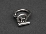 a silver ring with a knot on it on a black surface