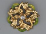 une broche en or ornée d'un diamant au centre