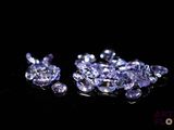 un gros plan sur un bouquet de diamants violets posés sur une surface noire