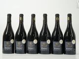six bouteilles de vin sont alignées sur une table
