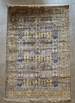 un tapis persan ancien présentant un motif multicolore sur fond beige