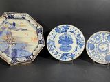 trois assiettes bleues et blanches sont posées sur une surface noire