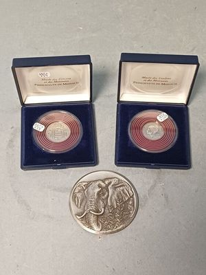 Il y a deux pièces d'argent dans une boîte bleue et une pièce d'argent dans une boîte bleue