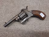 un gros plan d'un pistolet posé sur un tapis, avec une étiquette dessus