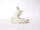 a white cat figurine sitting on a white surface