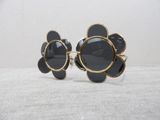 black and gold flower sunglasses with black lenses on a white surface