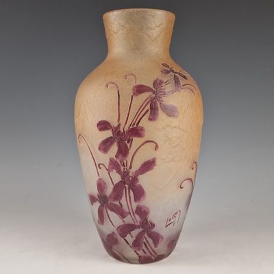 a vase with purple flowers on it sitting on a table