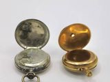 two different types of pocket watches on a white surface