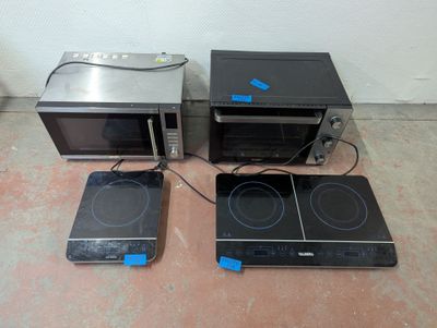 three microwaves that are sitting on the floor