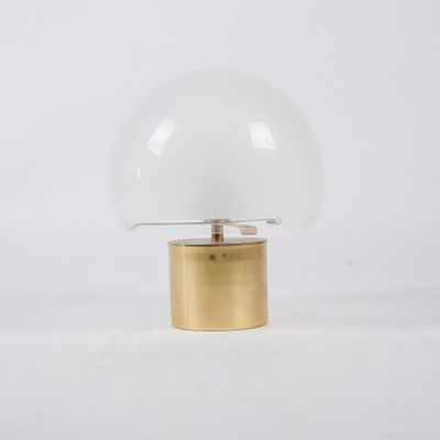 a white and gold table lamp with a glass dome on a gold base