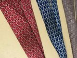 several different colored ties hanging on a wall next to each other