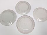 four white plates sitting on top of each other on a table