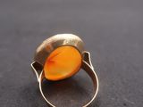 Gros plan sur une bague contenant une pierre orange