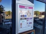 a menu in the window of a restaurant on the street