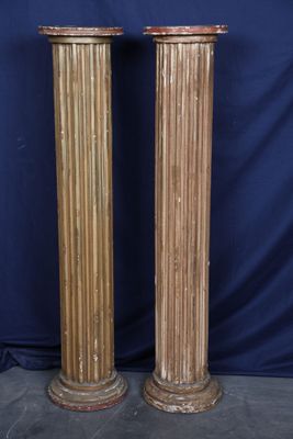 a pair of antique wooden columns with gold paint on them