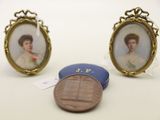 deux portraits miniatures représentant une femme et un penny posés sur une table