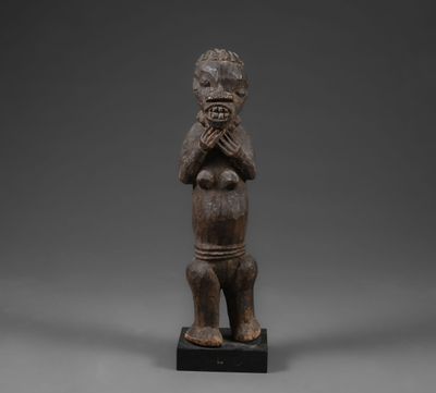 une statue en bois représentant un homme qui porte ses mains à son visage