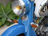 a close up of a blue motorcycle with a light on