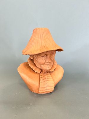wooden bust of an old man with a hat on his head