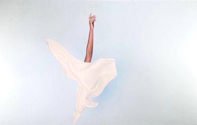 une femme en robe blanche qui saute en l'air