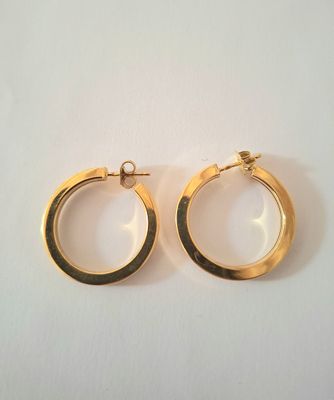 deux paires de boucles d'oreilles en or sur fond blanc