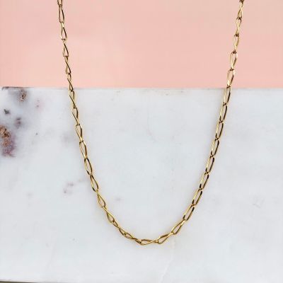 a close up of a gold chain necklace on a marble surface