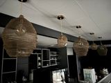 three wicker lamps hanging from the ceiling above a bar