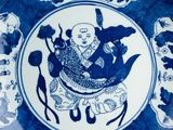 a blue and white plate with a picture of a man riding a dragon