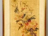 tableau représentant un bouquet de fleurs dans un cadre doré, posé sur un fond blanc