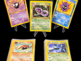 Quatre cartes Pokémon différentes sont représentées sur un fond noir.