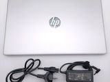 a laptop with a charger and power cord on the table