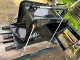 an image of a black skid steer attachment on a wooden pallet