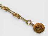un gros plan sur un collier en or orné d'un médaillon