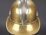 a gold helmet on a black stand on a gray background