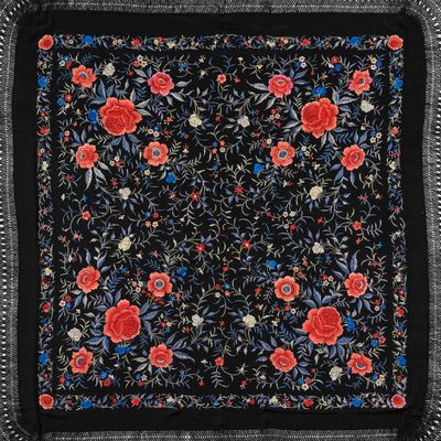 une écharpe à motifs floraux noirs et rouges, avec des franges