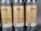 three bottles of wine are lined up on a table