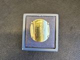 une photo d'une bague en or dans un écrin posé sur une table