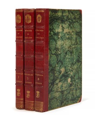 trois livres rouges superposés sur une surface blanche
