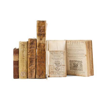 several old books sitting on top of each other on a white surface