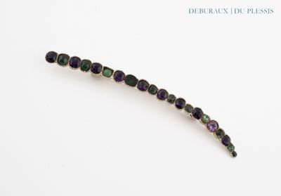 un gros plan d'une perle violette et verte sur une surface blanche