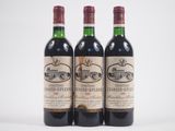 trois bouteilles de vin rouge posées l'une à côté de l'autre sur une surface blanche