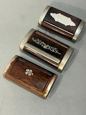 trois petites boîtes en bois posées les unes à côté des autres sur une table