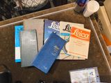 une pile de livres posée sur une table, à côté d'une souris d'ordinateur et d'un téléphone portable