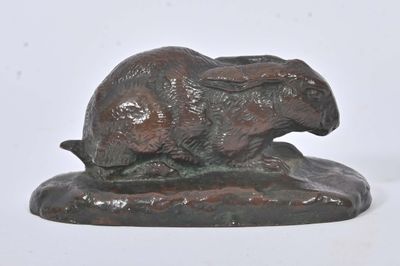 sculpture en bronze représentant un lapin posé sur un rocher, sur fond blanc